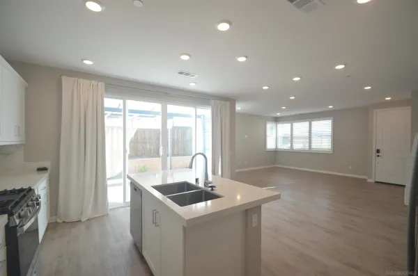 a kitchen with stainless steel appliances granite countertop a sink and a large window