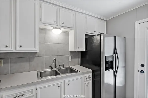 a kitchen with granite countertop a stove and a white cabinets