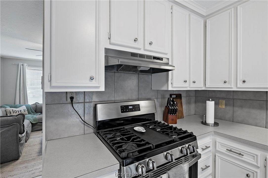 804 East 32nd Street Bryan, TX 77803 - Photo 12 of 22 a kitchen with granite countertop a stove and a white cabinets