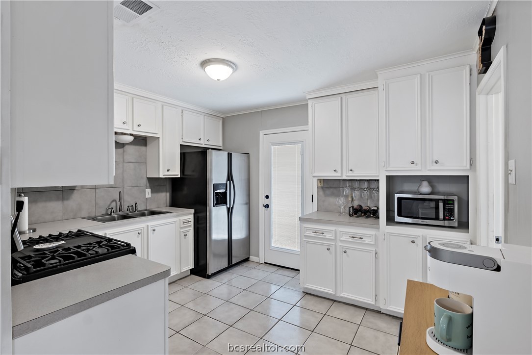 804 East 32nd Street Bryan, TX 77803 - Photo 14 of 22 a kitchen with white cabinets and appliances