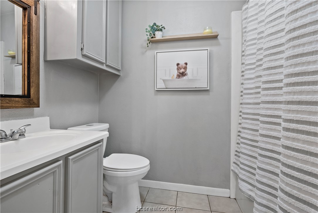 804 East 32nd Street Bryan, TX 77803 - Photo 19 of 22 a bathroom with a toilet a sink and a mirror