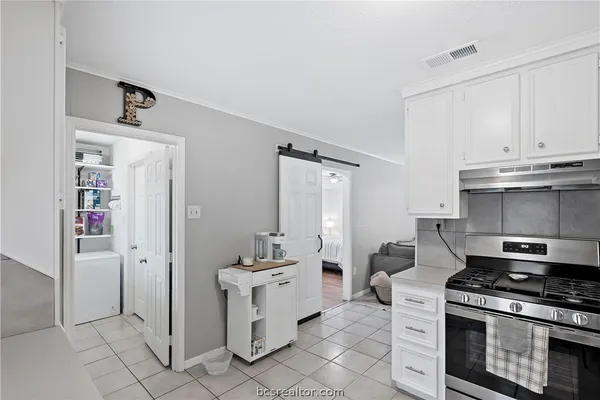 a kitchen with white cabinets and stainless steel appliances