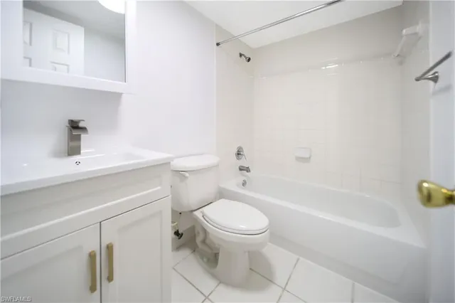a white toilet sitting next to a bathroom sink and vanity