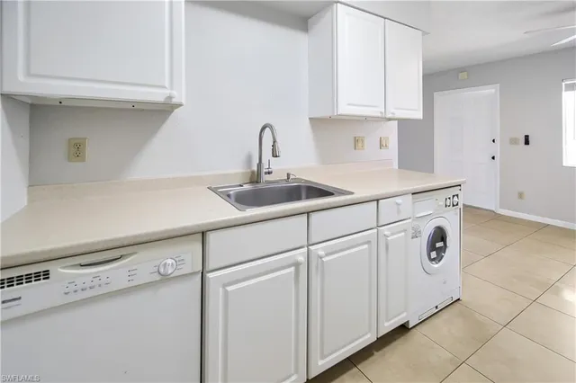 a kitchen with white cabinets and white appliances