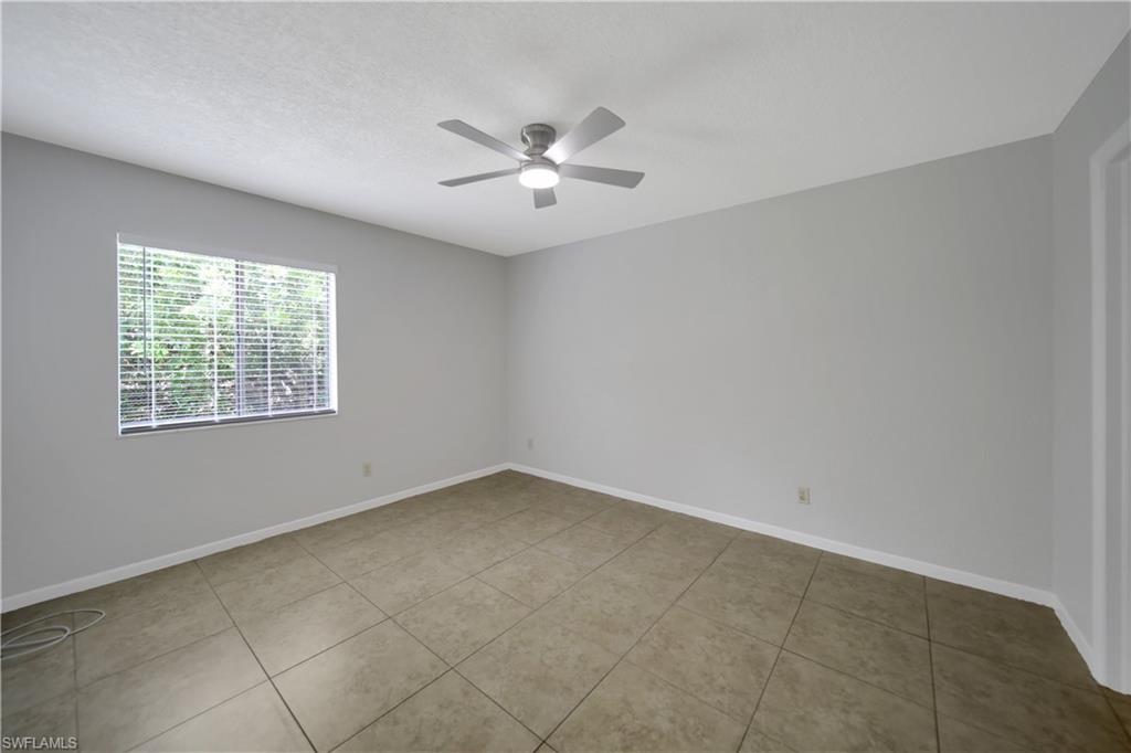 4621 Bayshore Drive, Unit Q4 Naples, FL 34112 - Photo 8 of 12 an empty room with windows and fan
