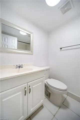 a bathroom with a toilet sink vanity and mirror