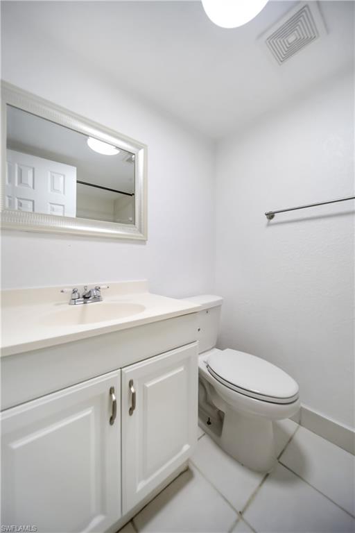 4621 Bayshore Drive, Unit Q4 Naples, FL 34112 - Photo 9 of 12 a bathroom with a toilet sink vanity and mirror