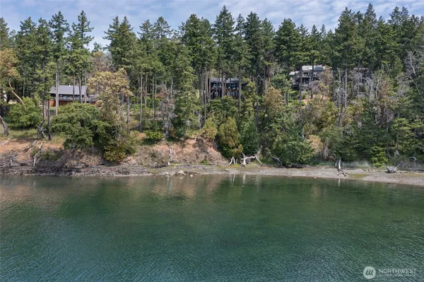 an aerial view of residential houses with outdoor space and lake view