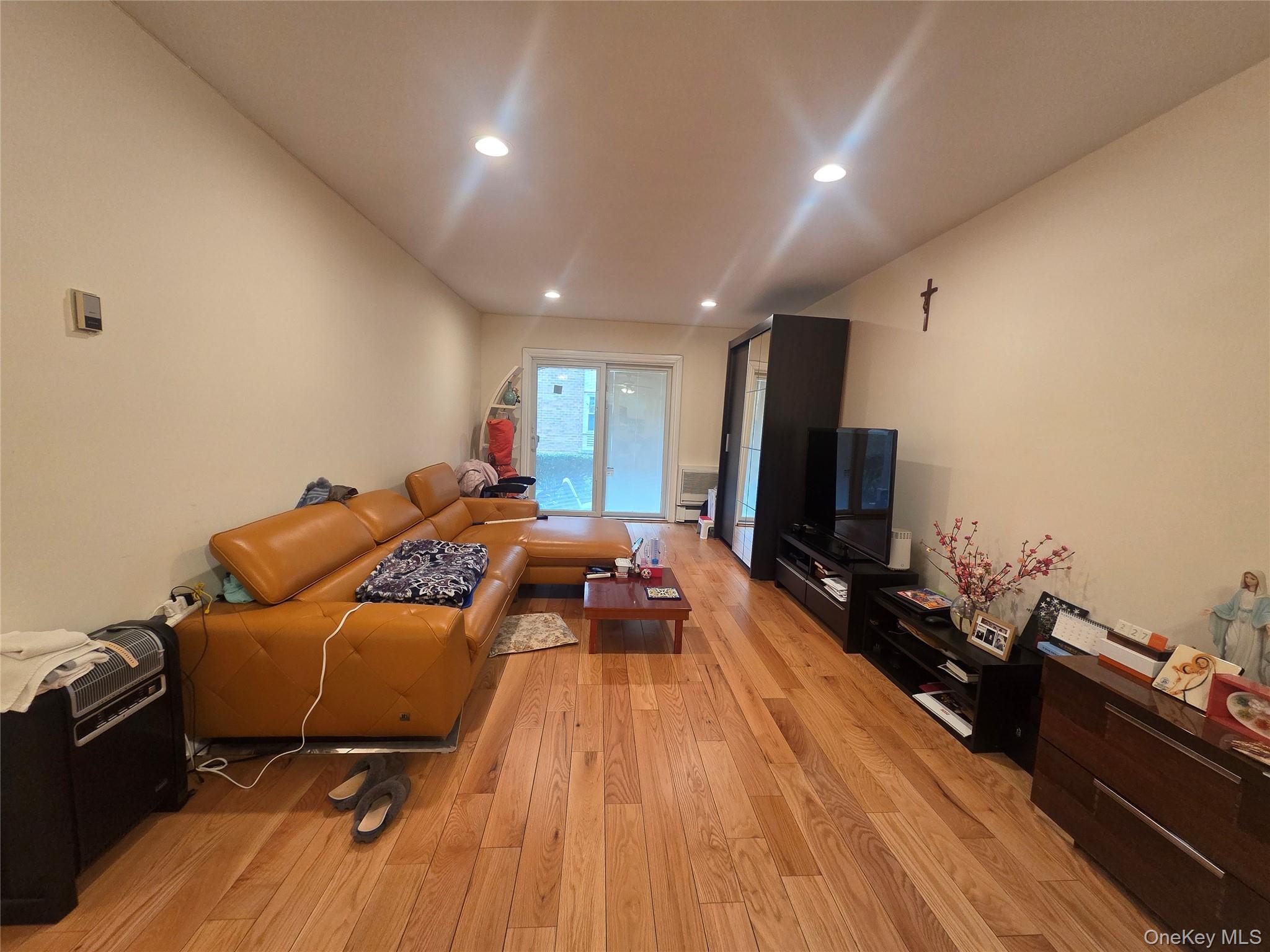 206-14 Emily Road, Unit 42L Queens, NY 11360 - Photo 2 of 9 a living room with furniture and a flat screen tv
