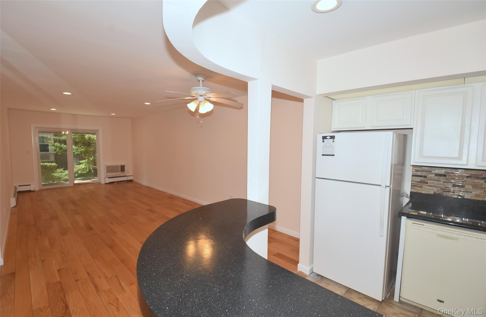 206-14 Emily Road, Unit 42L Queens, NY 11360 - Photo 2 of 14 a view of a kitchen with a refrigerator and wooden floor