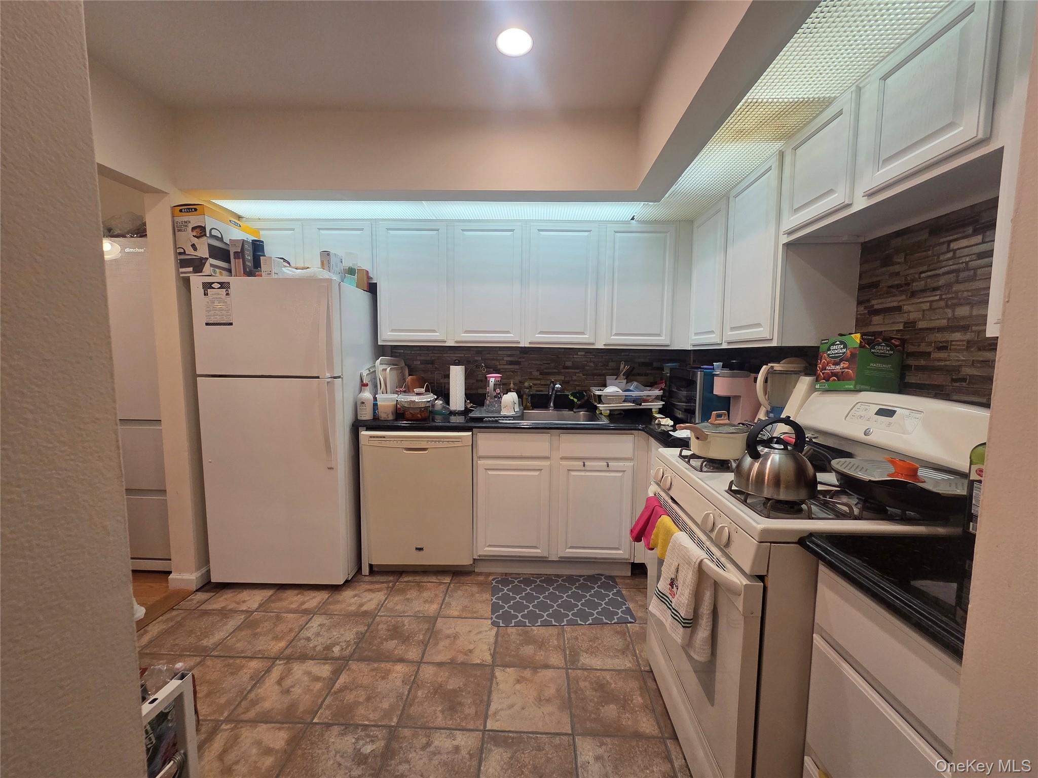 206-14 Emily Road, Unit 42L Queens, NY 11360 - Photo 4 of 9 a kitchen with a sink stove and refrigerator