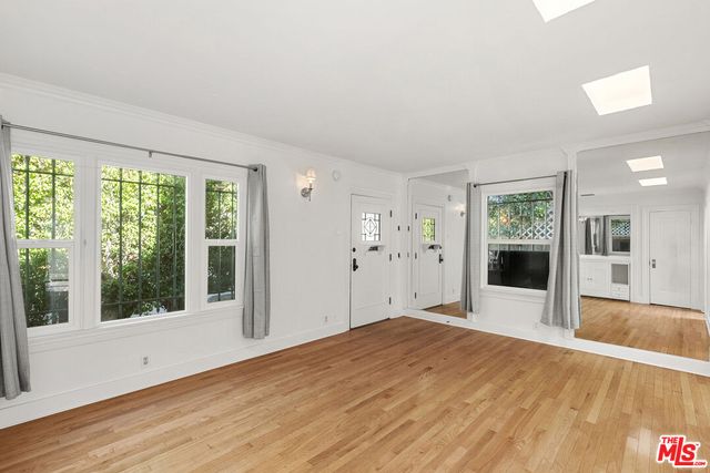 a view of a big room with wooden floor and windows