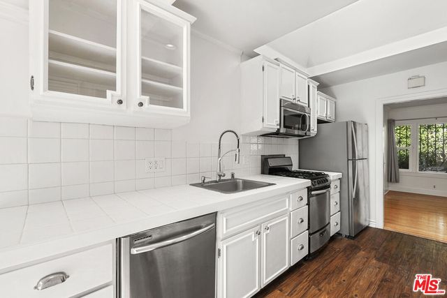 a kitchen with stainless steel appliances a sink stove and refrigerator