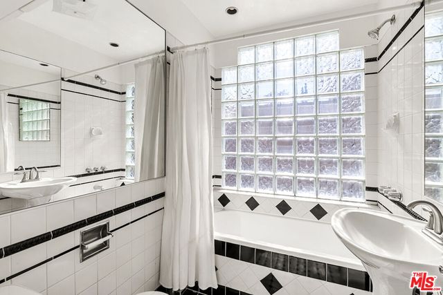 a bathroom with a sink a mirror and a shower