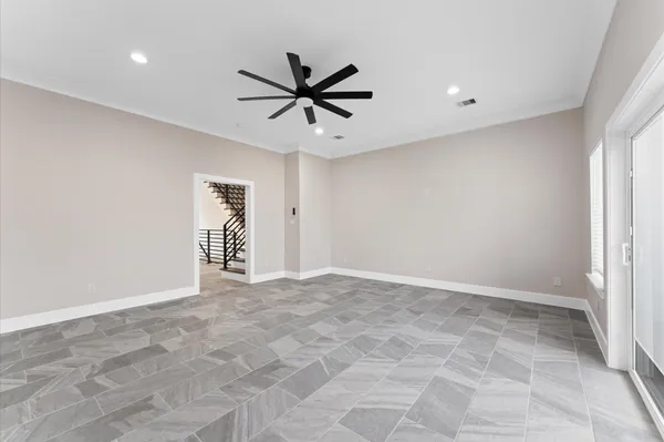 an empty room with a ceiling fan and window