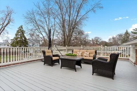 a roof deck with couches and wooden fence