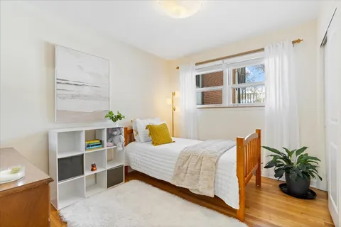 a bedroom with a bed a bookshelf and wooden floor