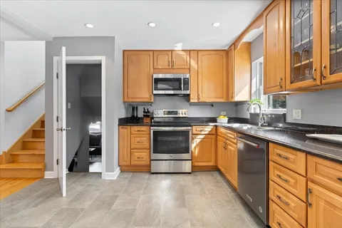 a kitchen with stainless steel appliances granite countertop a stove a sink and a refrigerator