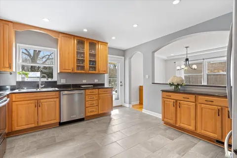 a large kitchen with stainless steel appliances granite countertop a stove a sink and a refrigerator