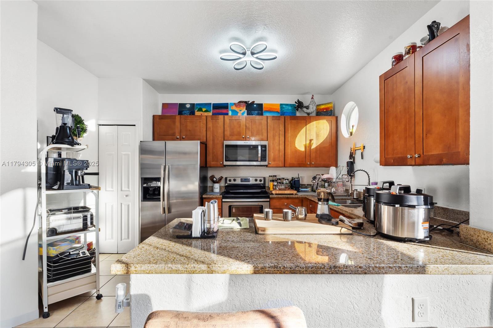 10012 Northwest 7th Street, Unit 107 Miami, FL 33172 - Photo 14 of 44 a kitchen with stainless steel appliances granite countertop a sink refrigerator and cabinets