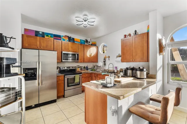 a kitchen with stainless steel appliances granite countertop a refrigerator and a stove top oven