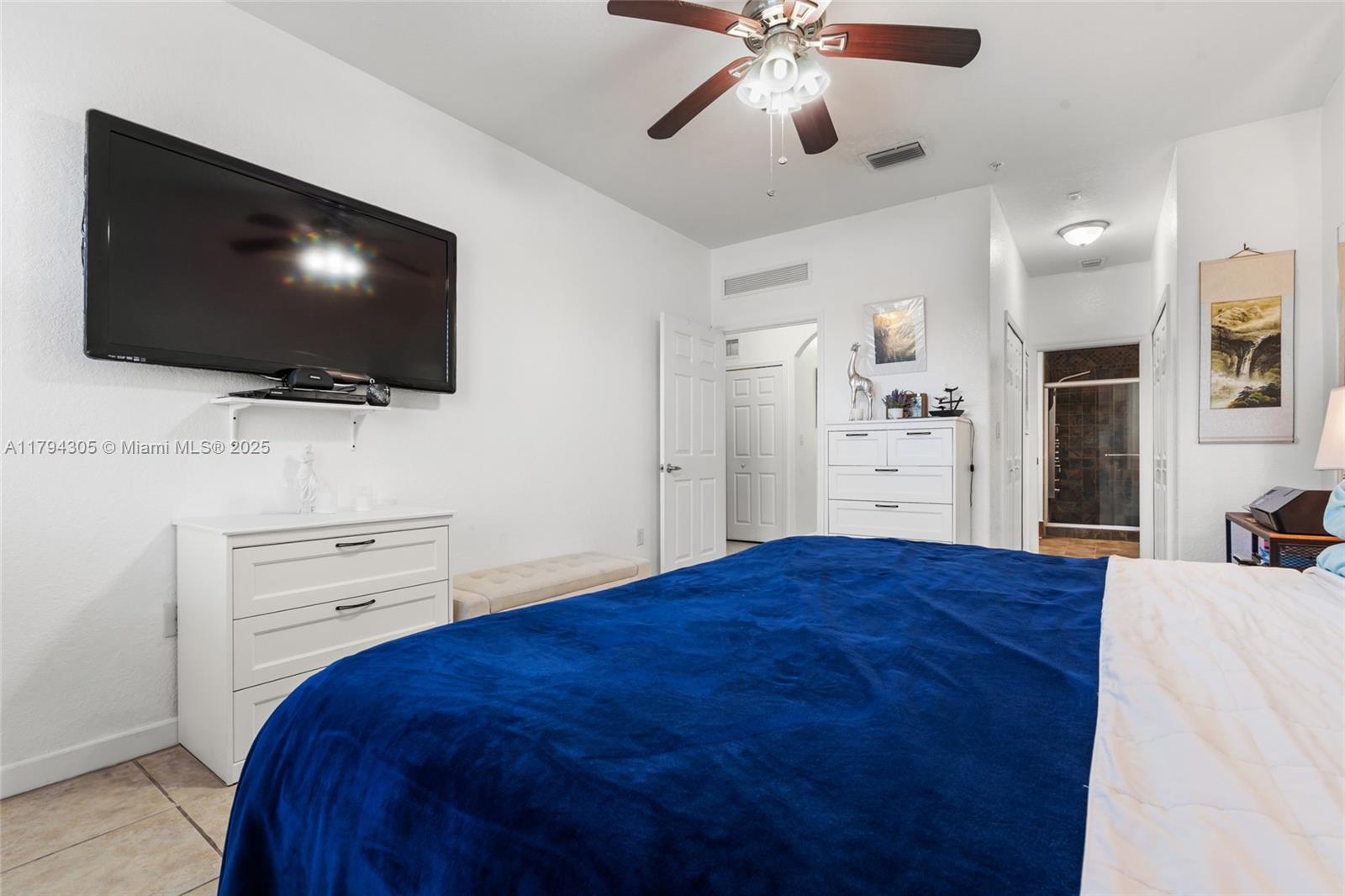 10012 Northwest 7th Street, Unit 107 Miami, FL 33172 - Photo 29 of 44 a bedroom with a bed and a flat screen tv