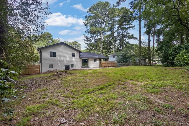 a front view of house with yard and trees in the background
