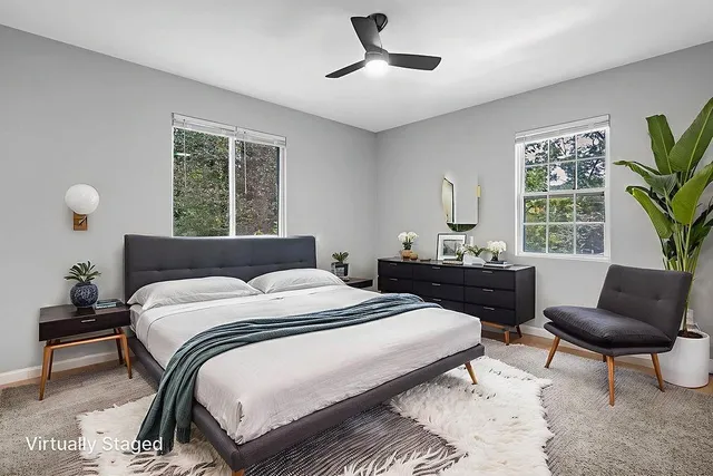 a bedroom with a bed and a couch next to a window