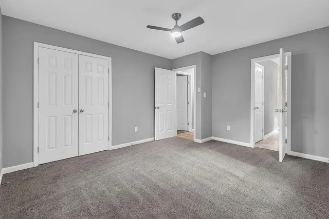 a view of an empty room and a ceiling fan