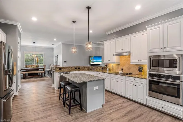 a kitchen with lots of counter space a sink appliances and cabinets
