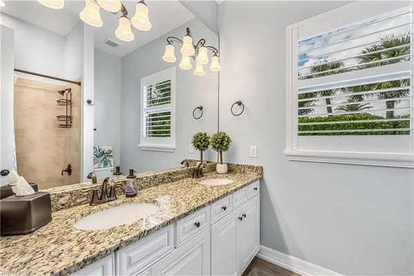 a bathroom with a granite countertop sink mirror and double