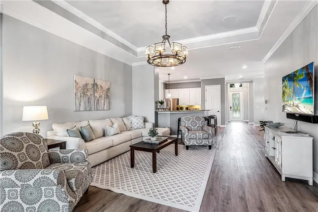 a living room with furniture a dining table and a chandelier