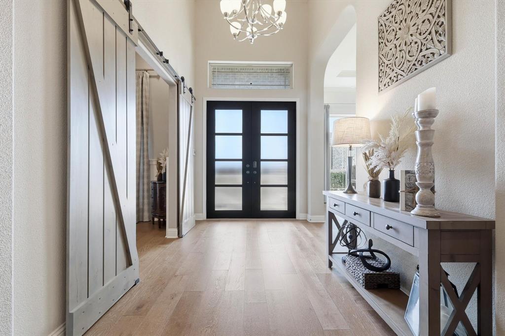 7751 Faught Road Northlake, TX 76226 - Photo 6 of 39 Foyer featuring light wood-finish flooring, a contemporary chandelier, and a transom window above the entry