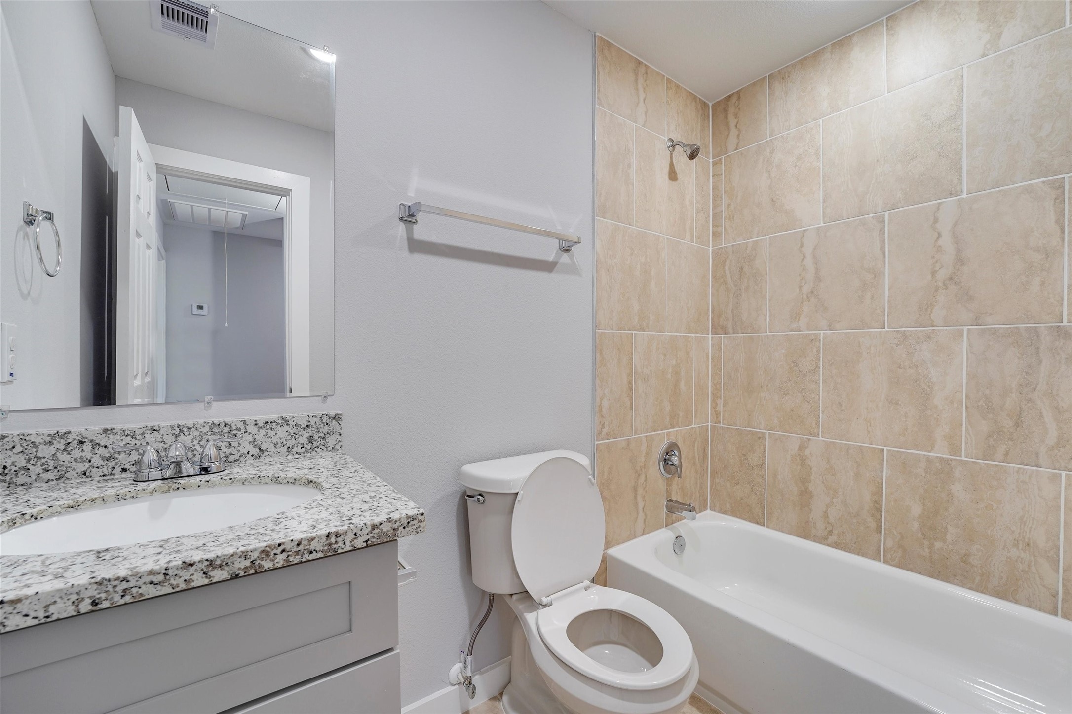 6716 Haight Street, Unit A Houston, TX 77028 - Photo 12 of 14 a bathroom with a granite countertop sink a toilet and bathtub