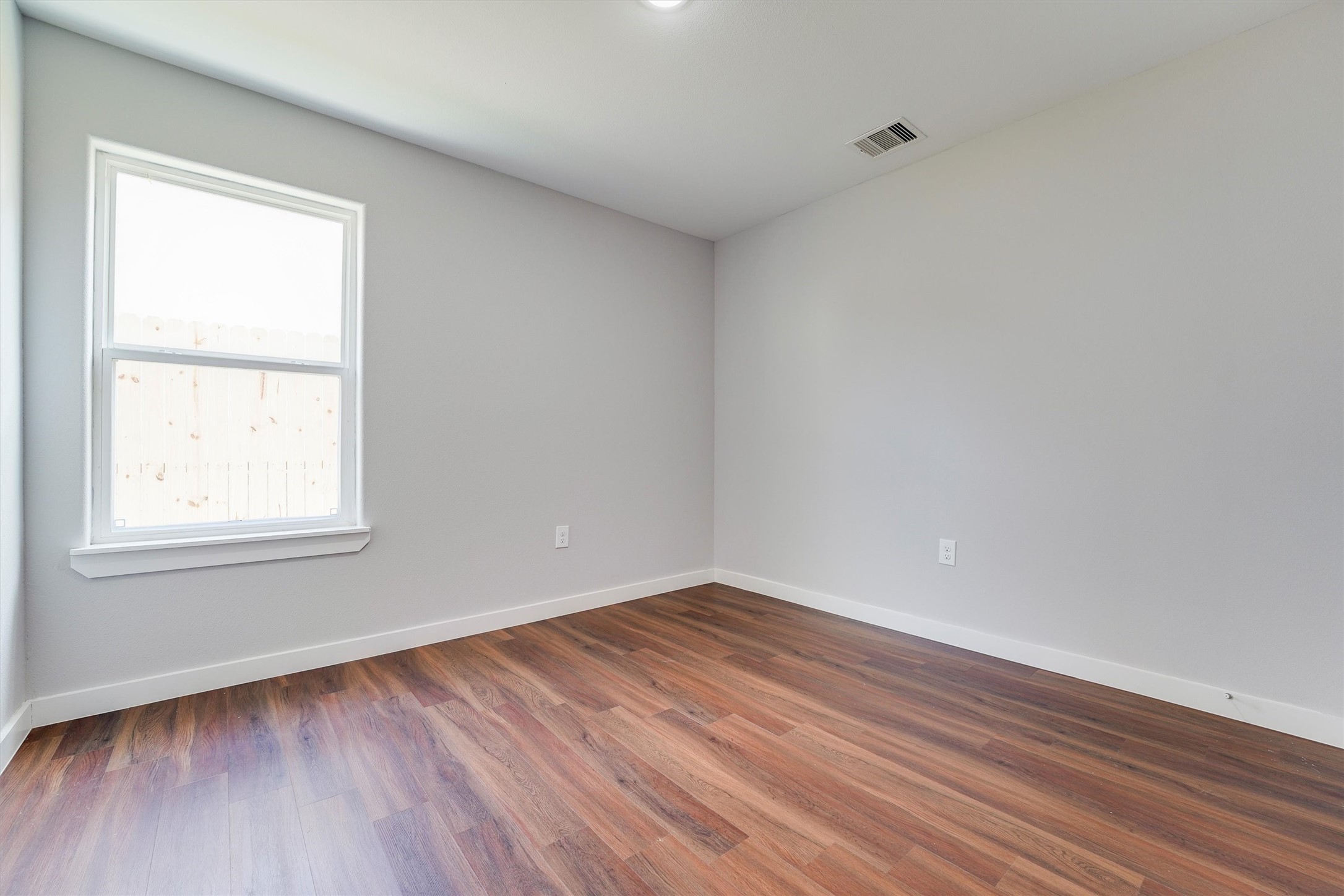 6716 Haight Street, Unit A Houston, TX 77028 - Photo 5 of 14 an empty room with wooden floor and windows
