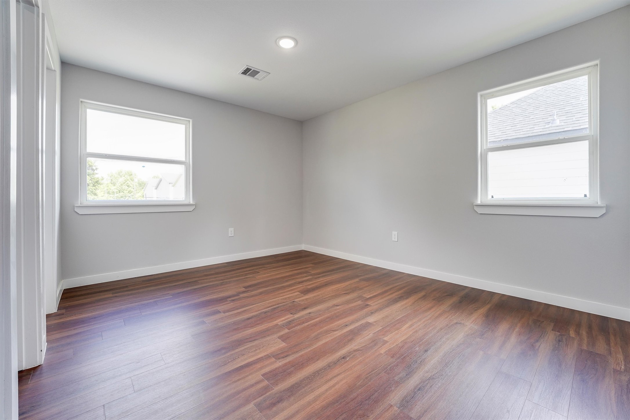 6716 Haight Street, Unit A Houston, TX 77028 - Photo 6 of 14 an empty room with wooden floor and windows
