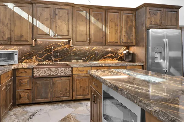 a kitchen with stainless steel appliances granite countertop a sink stove and refrigerator