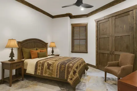 a bedroom with a bed a couch and a chandelier