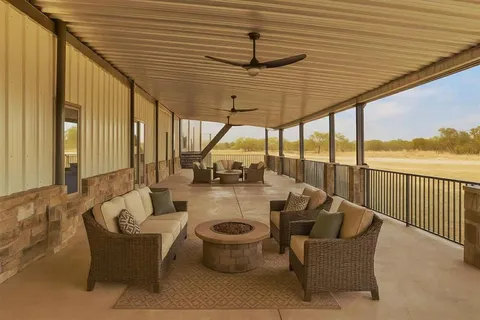 a view of a patio with couches chairs and wooden floor