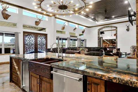 a kitchen with stainless steel appliances granite countertop a sink a stove and a wooden cabinets