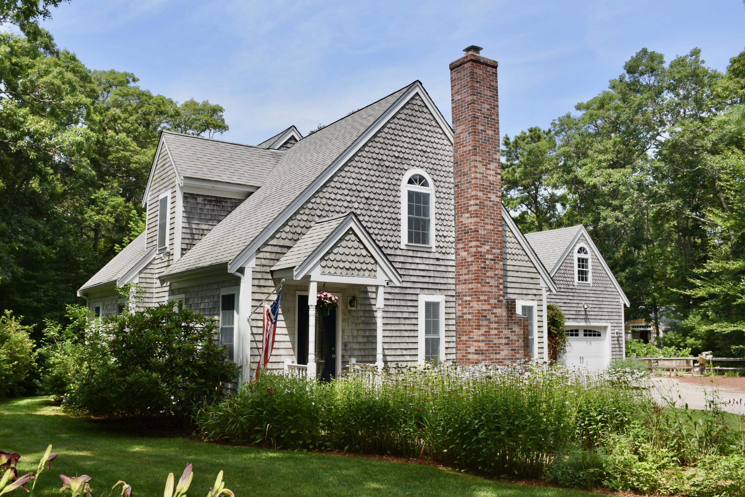 a front view of a house with a yard and trees