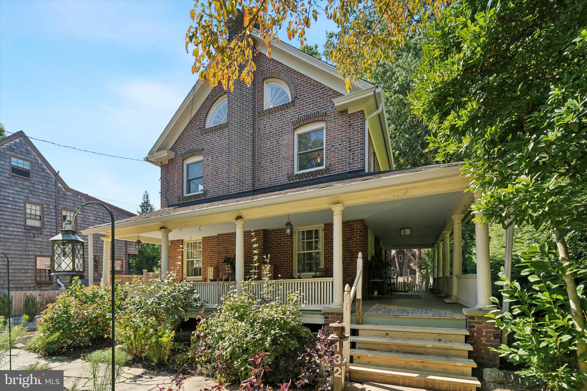 a view of a house with a small yard plants and large tree