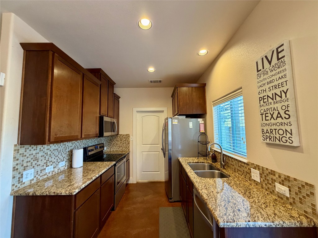 5503 Hiline Road Austin, TX 78734 - Photo 5 of 20 Kitchen featuring tasteful backsplash, appliances with stainless steel finishes, light stone countertops, recessed lighting, and finished concrete flooring