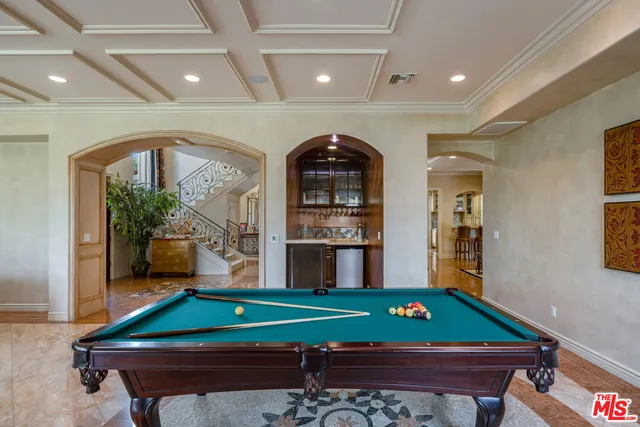 a room with pool table and windows