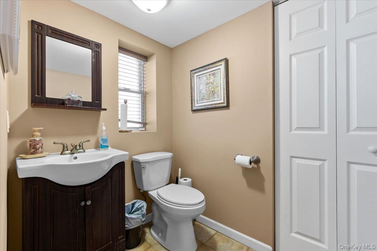 61 Winthrop Road Plainview, NY 11803 - Photo 24 of 37 a bathroom with a toilet a sink and mirror