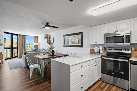 a kitchen with a sink a stove cabinets and wooden floor