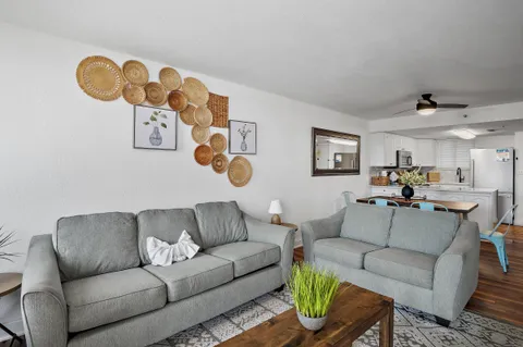 a living room with furniture kitchen view and a window