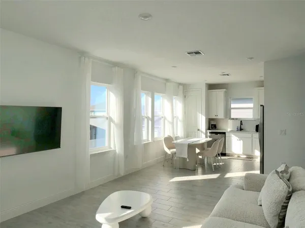 a living room with furniture a flat screen tv and a window