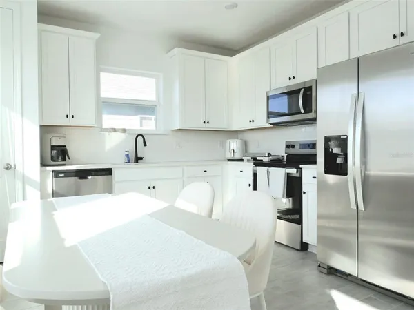 a large white kitchen with stainless steel appliances