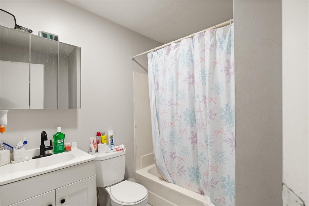 138 Franklin Street Lynn, MA 01902 - Photo 5 of 13 a bathroom with a sink a toilet and shower curtain